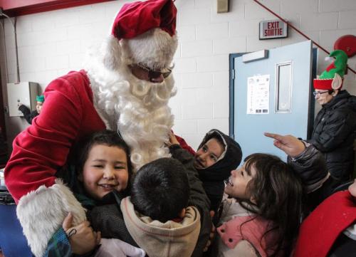 Santa (Doug Speirs) gets in lots of hugs from excited school kids as he arrives after a flight on the STARS helicopter. Around 150 kids from three Winnipeg School Division elementary schools, Strathcona, Mulvey and Dufferin, got to have lunch in the Winnipeg James Armstrong Richardson International Aiport's firehall where Santa just happened to be testing out the STARS helicopter. Fred Penner was on hand to perform some music too. 121217 - Monday, December 17, 2012 -  (MIKE DEAL / WINNIPEG FREE PRESS)