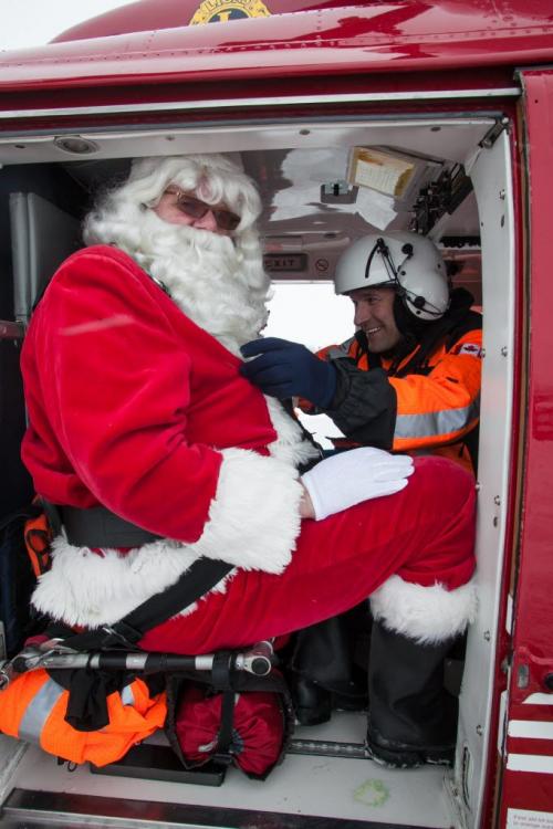 Santa Claus (Doug Speirs) is strapped into the STARS Air Amblunace by Flight Paramedic Grant Therrien before take off for Santa's test flight Monday afternoon. The Winnipeg Airports Authority partnered with STARS to bring in 150 students to meet Santa after his test flight. (Melissa Tait / Winnipeg Free Press)