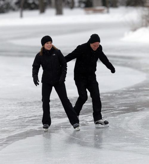 Darcelle Paquette and Aaron Seeger-Sitar skate on the pond at St. Vital Park. The crews at the park started to flood the pond yesterday and will continue to build and smooth out the natural rink 7 days a week. December 18, 2012  BORIS MINKEVICH / WINNIPEG FREE PRESS