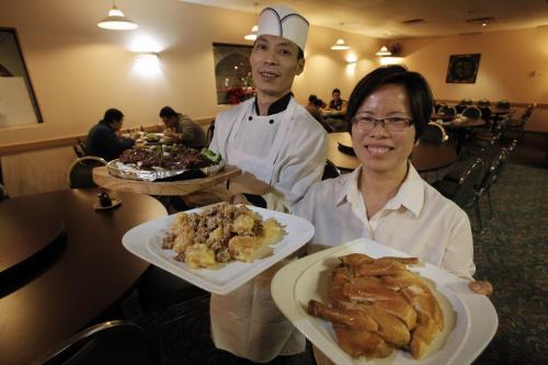 December 18, 2012 - 121218  -  Guang Han Wu (L), owner/chef, and Mei Zhi Yang with Braised Eggplant With Soy On Sizzling Iron, Walnut Shrimp and Hakga Special Salted Chicken at the Huang Pu River restaurant Tuesday December 18, 2012. John Woods / Winnipeg Free Press