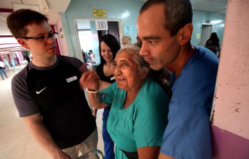 Ian Windle (left) and Victor Meaina flank Lucia Moyorga on a recuperative walk dowb the Managua wards hallway a day after her surgery.....