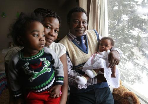 From left, Remedia Ayingono-Mitogo¤ holds daughter Joaquina Nsang-Ntutumu,2, with husband Alberto Ntutumu-Ntutumu Asue holds baby daughter Candida Asue- Ntutumu in their home in Winnipeg.  The family of seven has immigrated to Canada from Equatorial New Guinea as refugees. Gabrielle Giroday story    (WAYNE GLOWACKI/WINNIPEG FREE PRESS) Winnipeg Free Press  Dec.20   2012