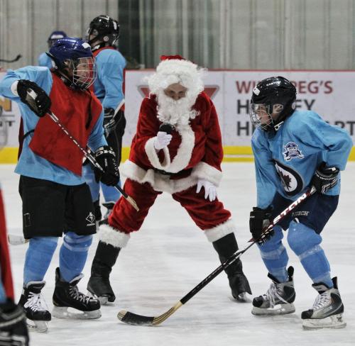 Santa drops the puck as kids from Ness Middle School take part in the Winnipeg Jets Hockey Academy program at the MTS IcePlex Thursday afternoon. Santa is keeping in shape by getting some ice time with the WJHA in the days leading up to Christmas next week.  121220 December 20, 2012 Mike Deal / Winnipeg Free Press