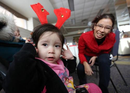 Hailey Nepinak, 2, adjusts reindeer antlers while her mother Gail Nepinak looks on, Saturday, December 22, 2012. The Nepinak family were among those attending a supper provided by the province, for families of missing and murdered women at the Clarion Hotel. Gail's sister, Tanya Nepinak, went missing in September of 2011. (TREVOR HAGAN/WINNIPEG FREE PRESS)