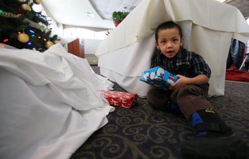 Jaxon McLean, 3, peaks at presents before Santa arrives to hand them out while at a supper provided by the province, for families of missing and murdered women at the Clarion Hotel, Saturday, December 22, 2012.  A member of Jaxon's family, Fonessa Bruyere, was murdered in 2007. (TREVOR HAGAN/WINNIPEG FREE PRESS)