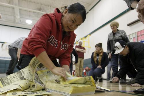 December 23, 2012 - 121223 - Miriam Arragutainaq from Sanikiluaq, Nunavut  play a contemporary inuit game at the Manitoban Urban Inuit Association celebration held at Greenway School Sunday December 23, 2012. In the game the player must roll a three and then gets an opportunity to tear as many pages from the phone book until the next person rolls a three. The person with the most pages wins. John Woods / Winnipeg Free Press