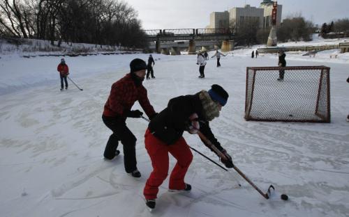 Family members take part in their annual Christmas Eve day family hockey game on the Assiniboine River by The Forks. Intern Meagan Franklin story    (WAYNE GLOWACKI/WINNIPEG FREE PRESS) Winnipeg Free Press  Dec.24   2012