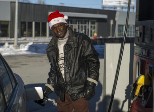 122512 Winnipeg -  Akin Oyetunjr fills up his car with gasoline Tuesday afternoon on Christmas Day while wearing a "Christmas Hat". DAVID LIPNOWSKI / WINNIPEG FREE PRESS