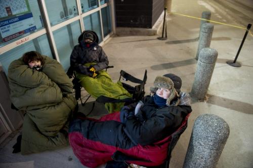 122512 Winnipeg -  Derek Kufley (21, black jacket far back with light green blanket) was first inline at BestBuy, and has been waiting since 6:30pm Tuesday evening of Christmas day to buy a Nikon DSLR digital camera, and expects to save $250, and get some accessories thrown in. Janelle Flett (18, big green sleeping bag, left) is waiting for a 3D smart TV, and expects to save $222. Her boyfriend Charles Clarke (18, bottom right) is waiting for a PlayStation TV, and expects to save $200. DAVID LIPNOWSKI / WINNIPEG FREE PRESS