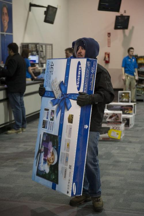 122612 Winnipeg -  Paul Johnson walks out of the St. James Best Buy after purchasing a 46" flatscreen TV Wednesday morning. The first customers walked through the door for Boxing Day deals at 6AM at the St. James Best Buy.  DAVID LIPNOWSKI / WINNIPEG FREE PRESS