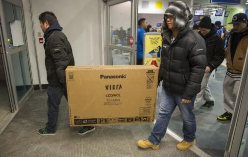 122612 Winnipeg -  Customers walk out of the St. James Best Buy with a flat screen TV Wednesday morning. The first customers walked through the door for Boxing Day deals at 6AM at the St. James Best Buy.  DAVID LIPNOWSKI / WINNIPEG FREE PRESS