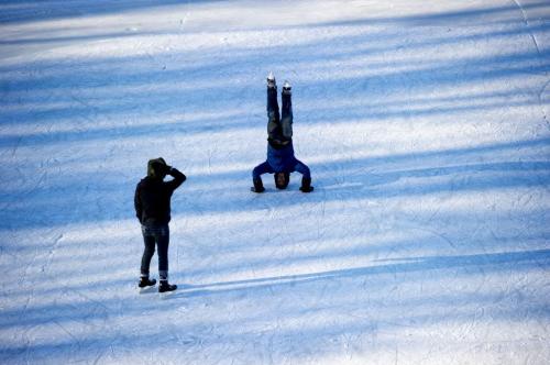 122612 Winnipeg - Coral Maloney watches her friend Simon Hon do a handstand on the River Trail at The Forks Wednesday on Boxing Day.  DAVID LIPNOWSKI / WINNIPEG FREE PRESS