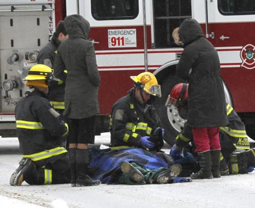 An injured cyclist is cared for by Fire Fighters on Harrow St. at Grosvenor Ave. while they wait for an ambulance to arrive.  . (WAYNE GLOWACKI/WINNIPEG FREE PRESS) Winnipeg Free Press  Dec.28   2012