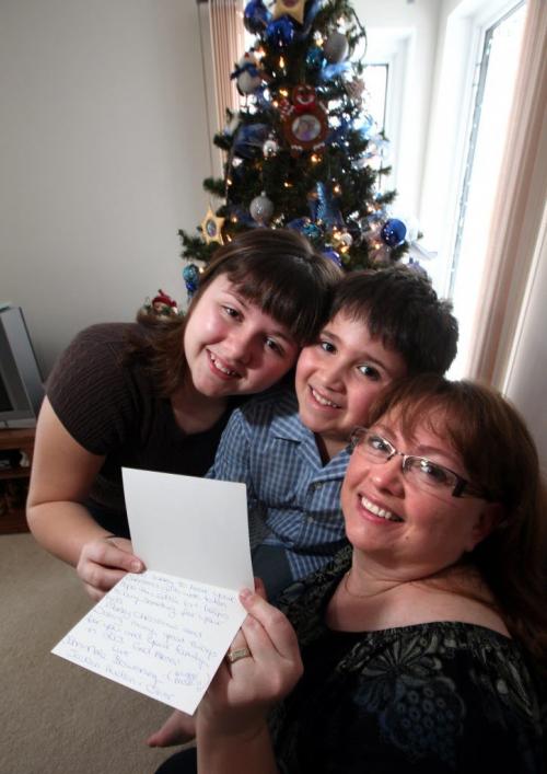 Trina Cimino, poses with her kids Kevin 8, and Sarah 11 holding a card from the School For the Deaf. Kids from the school across the road from her home helped out the family collecting donations after a holiday break in. Gabrielle's story. December 28, 2012 - (Phil Hossack / Winnipeg Free Press)