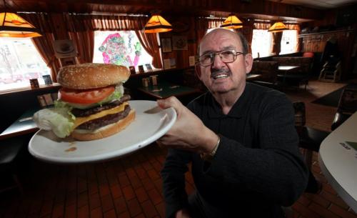 John Ginakes shows off one of his signature burgers at the Thunderbird Restraunt. "Icon" See  Dave Sanderson story. December 28, 2012 - (Phil Hossack / Winnipeg Free Press)