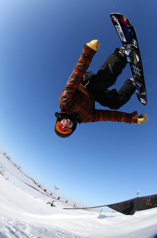 Eason Cerasani backflips over a tabletop jump while snowboarding at Spring Hill, Saturday, December 29, 2012. (TREVOR HAGAN/ WINNIPEG FREE PRESS)