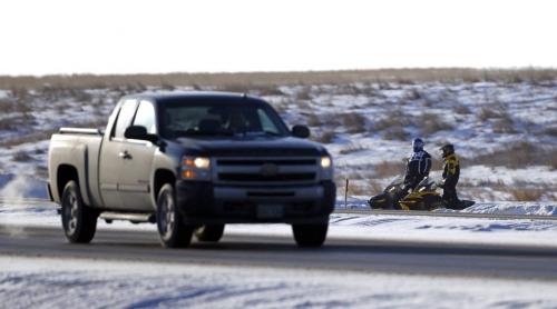 Snowmobilers wait in the ditch to cross highway 59 into the 59er, Saturday, December 29, 2012. (TREVOR HAGAN/WINNIPEG FREE PRESS)