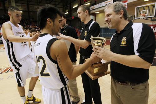 December 30, 2012 - 121230 - Garden City Fighting Gophers Josh Magpantay (42) hands off the trophy to his coach Phil Penner after defeating the Oak Park Raiders in the high school final of the Wesmen Classic at the University of Winnipeg Sunday December 30, 2012. Garden City defeated Oak Park for their third straight championship. John Woods / Winnipeg Free Press