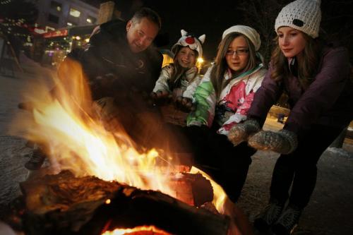 December 31, 2012 - 121231 - Kelly Thiessen, his daughters Peyton and Taylor, and friend Lauren Starodub warm up at a fire on New Year's Eve at The Forks December 31, 2012.  John Woods / Winnipeg Free Press