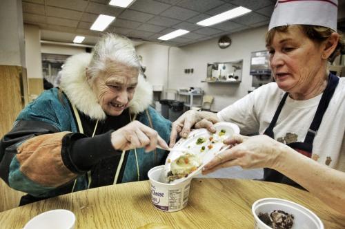 Volunteer Bonnie Stafford (right) helps Phyllis Ark, 78, put her New Years Day turkey dinner into a container during the second sitting of the Union Gospel Mission's New Years Day service.  130101 January 01, 2013 Mike Deal / Winnipeg Free Press