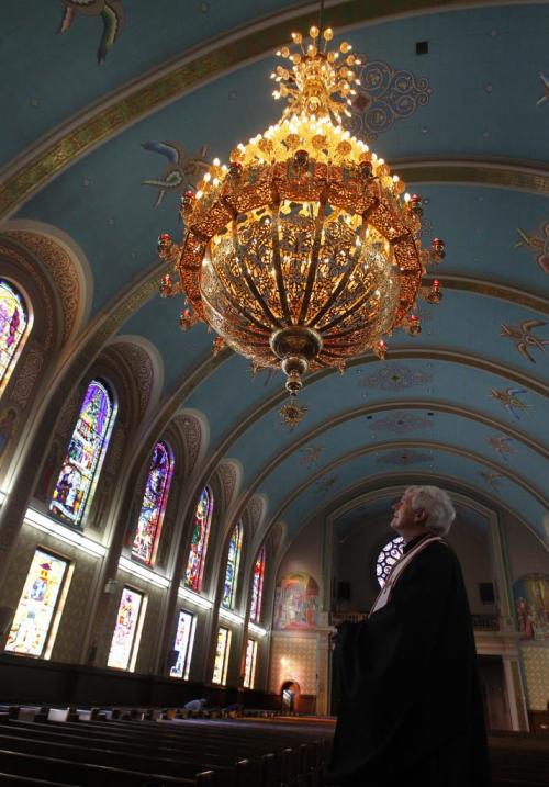 The Rt. Rev. Msgr. Mitrat Michael Buyachok with the new chandelier made in Greece especially for the Ukrainian Catholic Metropolitan Cathedral of Sts. Vladimir And Olga that was installed last week in time for the celebration of Ukrainian Christmas Eve Sunday Jan.6th. The 385 kg. chandelier is made of brass and is 24 carat gold plated and cost over $30,000 paid for by a  family donation. It took twelve men to install it.   see info   . (WAYNE GLOWACKI/WINNIPEG FREE PRESS) Winnipeg Free Press  Jan.3    2013