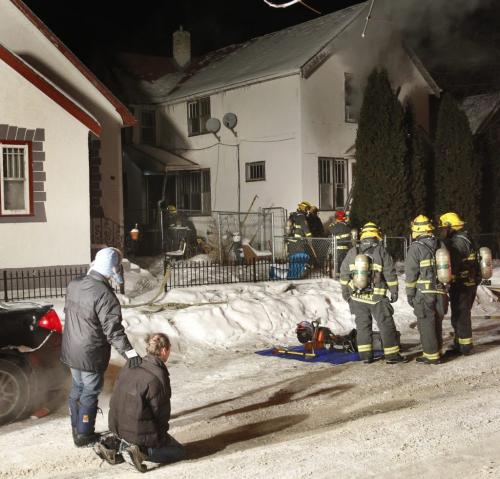 The upstairs tenant of 91 Grove St. is on his knees watching fire fighters extinguish the house fire and search for pets inside.    Jason Bell story  . (WAYNE GLOWACKI/WINNIPEG FREE PRESS) Winnipeg Free Press  Jan. 4 2013