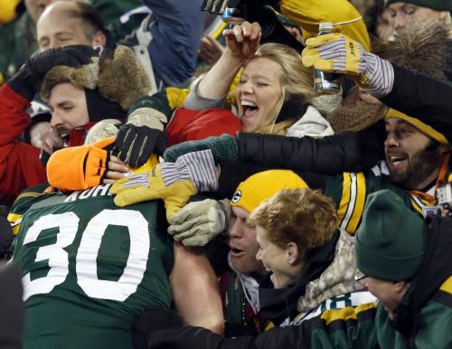 Green Bay Packers fullback John Kuhn (30) jumps into the crowd to celebrate his second touchdown of the game against the Minnesota Vikings during their NFL NFC wildcard playoff football game in Green Bay, Wisconsin, January 5, 2013.  REUTERS/Tom Lynn     (UNITED STATES - Tags: SPORT FOOTBALL)