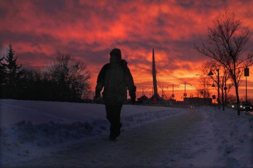 Calm Before Storm- A pedestrian walks near the Esplanade Riel Bridge pedestrian bridge Thursday morning with a spectaular morning sky in the rear- Things will rapidly change as a Winter storm advisory has been issued for Winnipeg- Standup photo January 10, 2012   (JOE BRYKSA / WINNIPEG FREE PRESS)