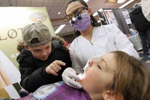 January 13, 2013 - 130113  -  Dr. Adelina Tan of Lotus Dental Care gives a free dental exam to Navaeh Braun as her brother Rain looks on at the Health and Wellness Show at the Convention Centre Sunday January 13, 2013.  John Woods / Winnipeg Free Press