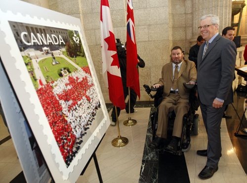 MP Steven Fletcher  and Mb priemier Greg Selinger  unveil new stamp=- Canada Post has released a new stamp depicting Winnipeg's  Canada Day Living Flag from 2012  , 3000 Manitobans  volunteered wearing red and white t-shirts to make flag on the Manitoba Legislative grounds .Bruce Owen story  KEN GIGLIOTTI / JAN 14 2013 / WINNIPEG FREE PRESS. Original photo of the living flag taken for Canada Post by Dan Harper.