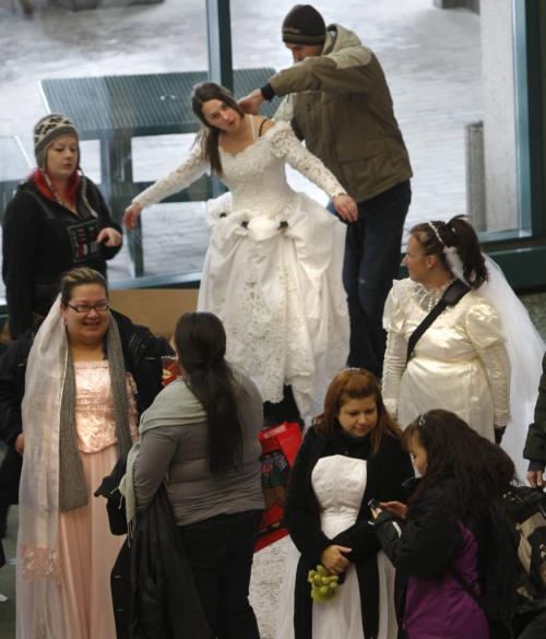 David McNabb lends some help to his sister Kim McNabb  one of the aprox. 80 women at the Winnipeg Convention Centre Friday prior to taking part in the "Runaway Brides" scavenger hunt throughout downtown Winnipeg. The first bride back with the four items hidden wins a Dream Wedding at Southwood Golf & Country Club valued at more than $20,000. The brides wore borrowed gowns or purchased them at second hand shops for the event presented by 103.1 Virgin Radio, The Wonderful Wedding Show, and Southwood Golf & Country Club.  (WAYNE GLOWACKI/WINNIPEG FREE PRESS) Winnipeg Free Press  Jan. 18 2013