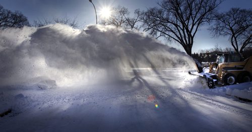 Snow is blown out of a sidewalk on Assiniboine Ave. in front of a brilliant blue sky backdrop with a temperature a of -27C Monday.   (WAYNE GLOWACKI/WINNIPEG FREE PRESS) Winnipeg Free Press  Jan. 21 2013