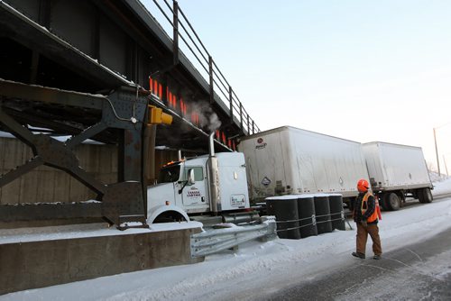 Brandon Sun 23012013 A semi trailer sits partially under the railway bridge at Kemnay on Wednesday morning after failing to clear the height of the bridge. The eastbound lane of Highway 1A was closed until the semi could be towed away from the bridge. (Tim Smith/Brandon Sun)