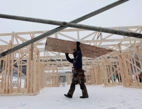 Jay Dyck wtih Garnet Construction a sheet of plywood  to the construction site on the Assinihoine River at the Forks where the company is helping a group of architecture students from Montreal to put together a the "Big City" warming hut Thursday afternoon. Jan 24, 2013, Ruth Bonneville  (Ruth Bonneville /  Winnipeg Free Press)