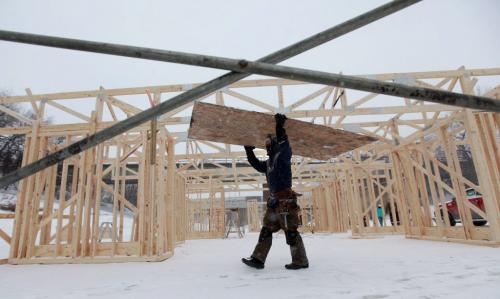 Jay Dyck wtih Garnet Construction a sheet of plywood  to the construction site on the Assinihoine River at the Forks where the company is helping a group of architecture students from Montreal to put together a the "Big City" warming hut Thursday afternoon. Jan 24, 2013, Ruth Bonneville  (Ruth Bonneville /  Winnipeg Free Press)