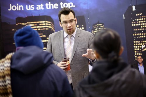 Brandon Sun 24012013 Zachary Minuk, Manager of Recruitment and Communications for the CGA of Manitoba, speaks with visitors to the career fair at Assiniboine Community College's Victoria Ave. East campus on Thursday.  (Tim Smith/Brandon Sun)
