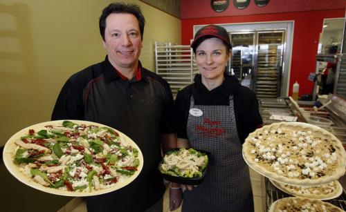 PIZZA WARS in Winnipeg companies are gearing up for stiff competition  from new players coming into the market place co-owners Doug and his wife Lisa  Sanders from Papa Murphy's  on Regent Ave  with  take and bake  ( take home and bake yourself) left Herb Chicken  Mediterranean  deLite pizza  and right a dessert pizza  KEN GIGLIOTTI / JAN. 25 2013 / WINNIPEG FREE PRESS