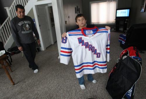 Warroad, Minnesota- 9 year old Daimon Gardner  shows his jerseyhis home in Warrod, Minnesota with his father Vince looking on.  He plays on the  Warrod squirt a team-See Randy Turners hockey FYI  story- January 29, 2013   (JOE BRYKSA / WINNIPEG FREE PRESS)