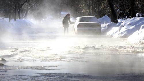 A motorist clears snow off a car parked on Vernon Rd. in St. James after a  water main break on Lodge Ave. at Whytewold Rd. Thursday morning. The water main break flooded Lodge Ave. between Vernon Rd. and Olive St. and nearby streets. (WAYNE GLOWACKI/WINNIPEG FREE PRESS) Winnipeg Free Press  Jan.31  2013