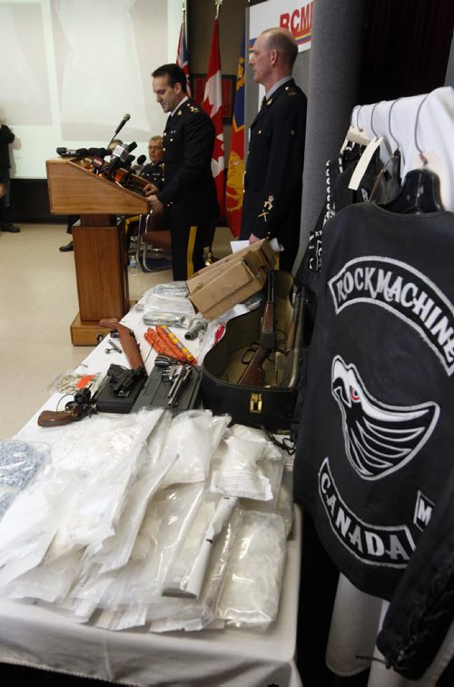 The RCMP announce a major take down called Operation Dilemma  involving 140 RCMP , targeting the  Rock Machine  Motorcycle Gang , 11 people were charged and drugs , guns and money seized in pic Assistant Director Kevin Brosseau  talks about the  operation with right Cpl Myles Hiebert beside him - cocc , GUNS  CLOTHING IN PIC  KEN GIGLIOTTI / JAN. 31 2013 / WINNIPEG FREE PRESS