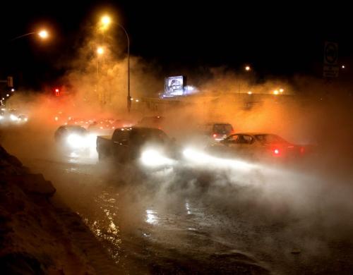 Traffic moves slowly on Logan Ave. at Arlington St. after a Friday morning water main break flooded the intesection and created a dense fog.   web story (WAYNE GLOWACKI/WINNIPEG FREE PRESS) Winnipeg Free Press  Fe.1 2013