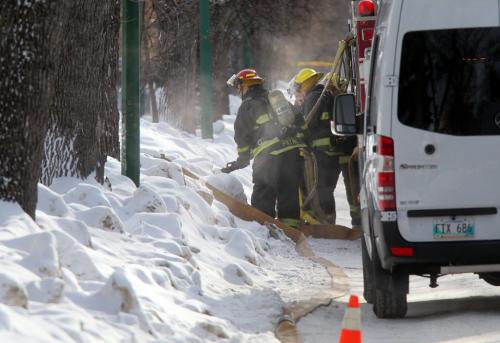 Fire crews stand by hoses ready as Police TAC teams and city fire and ambulance crews surrounded a home in the 500 block of Simcoe street Friday afternoon after a man broke into a home then barracaded homself in after police arrived. See webbie. Feb 1, 2013 - (Phil Hossack / Winnipeg Free Press)