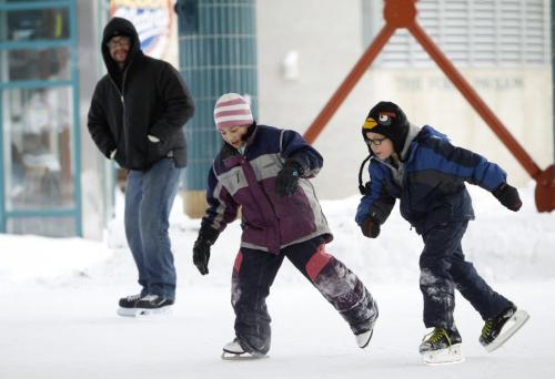 David Nace looks on as his kids, Zardee, 9, and Zavier, 6, skate on the rink at The Forks, Saturday, February 2, 2013.(TREVOR HAGAN/ WINNIPEG FREE PRESS)