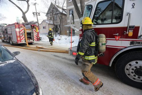 Firefighters at the scene of a fire in a house on Beverley Street near Notre Dame Avenue, Sunday, February 3, 2013.  (TREVOR HAGAN/WINNIPEG FREE PRESS)
