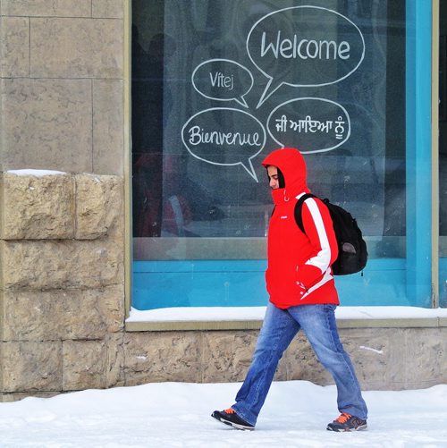 Not exactly welcome weatherÄ¶ Red River College student Juan Bonilla walks by window sign on Princess Street in Winnipeg's Exchange District over the lunch hour as the temperature hit the expected low of the day at -20C. 130205 February 05, 2013 Mike Deal / Winnipeg Free Press