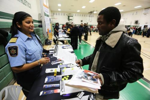 Correctional Manager, Jenefer Swanson, from Correctional Services Canada, speaks with Kayode Oderemi, at the Afro-Caribbean job fair at Elmwood High School. Last year, about 1300 people attended the fair. Saturday, February 9, 2013. (TREVOR HAGAN/WINNIPEG FREE PRESS)