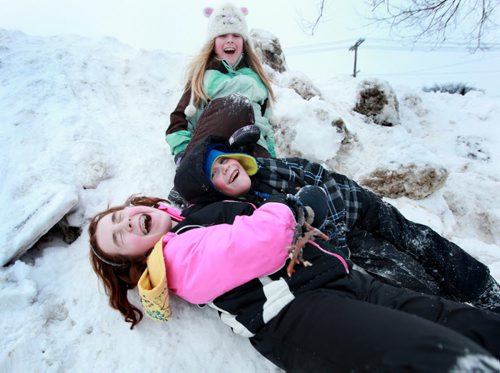 Eight year old Kiera Coupland (hat, green)  plays with her sister Aliyah - 12yrs (in pink) and her little brother Aiden 6yrs" in deep snow next to thier home on a warm winter Saturday afternoon. Standup photo.  Feb 09, 2013, Ruth Bonneville  (Ruth Bonneville /  Winnipeg Free Press)