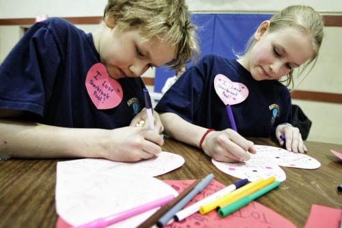 Aiden Dueck Thiessen, 9, and his sister Jubilee (right), 12, finish up valentine cards they made while parents and neighbourhood residents discuss the issues surrounding the continued closure of the Sherbrook Pool several kids made valentines cards that will be put up on the side of the pool later this week.  130214 February 14, 2013 Mike Deal / Winnipeg Free Press
