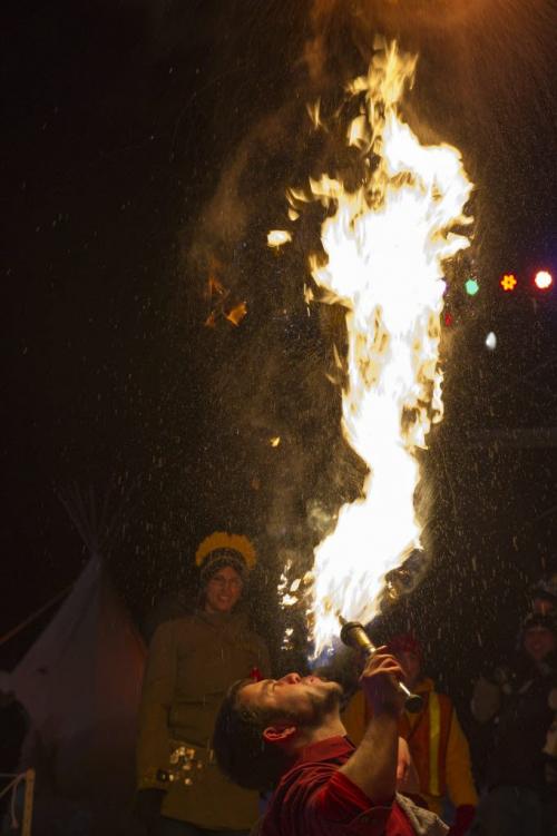 021513 Winnipeg-  Isaac Girardin of Skill Circus blows fire into the air as partner Lynette Didur looks on prior to the opening ceremony of the 44th edition of the Festival du Voyageur Friday night at Voyageur Park. DAVID LIPNOWSKI / WINNIPEG FREE PRESS