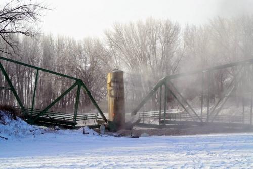 The smoke clears after the St. Jean Baptiste bridge was demolished around 9 AM Saturday morning in front of a gathering of townspeople and local residents.  130216 February 16, 2013 Mike Deal / Winnipeg Free Press